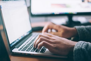 Laptop keyboard and hands Glenn Carstens Peters on Unsplash